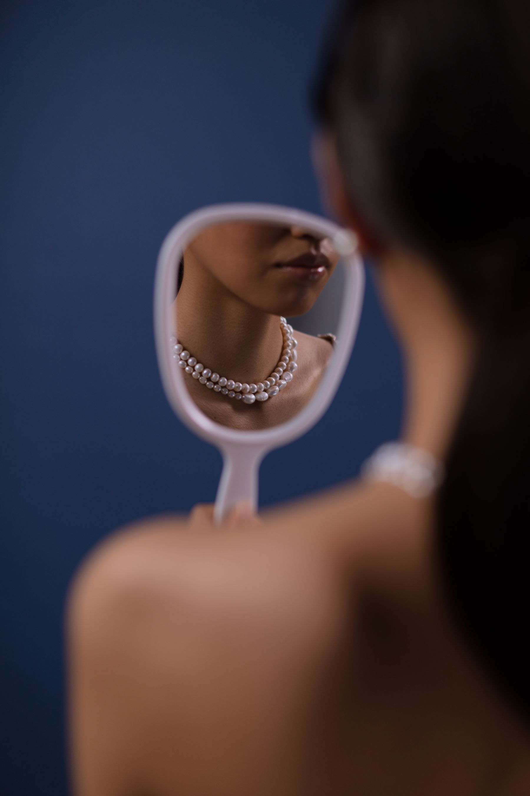 Reflet d'un collier de perles dans un miroir à main